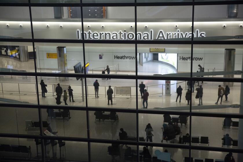 FILE - People in the arrivals area at Heathrow Airport in London, Jan. 26, 2021. The number of people moving to Britain reached a record high of more than 600,000 in 2022, government figures showed Thursday May 25, 2023. (AP Photo/Matt Dunham, File)