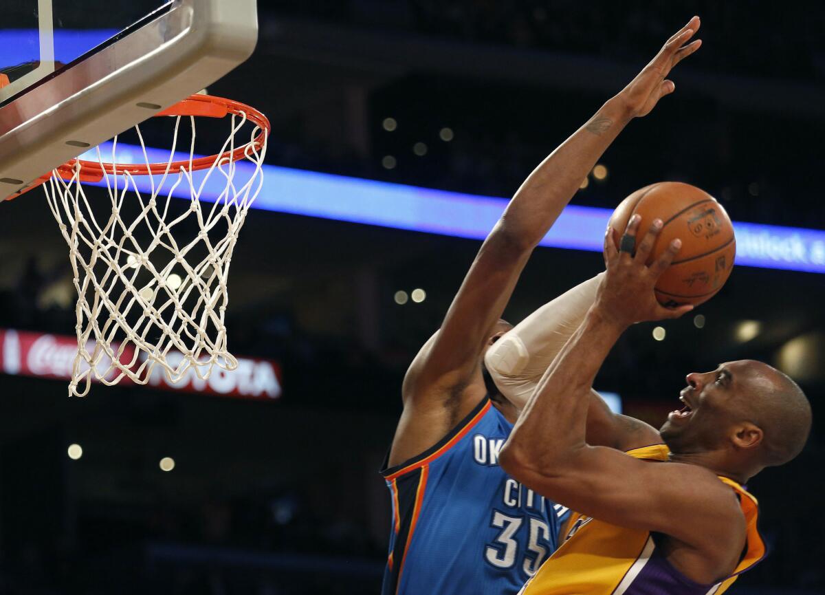 Lakers guard Kobe Bryant has his shot challenged by Thunder forward Kevin Durant during their game Wednesday night at Staples Center.