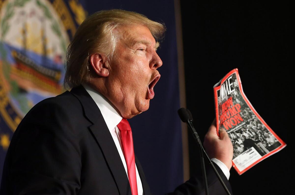Donald Trump shows off a Time magazine with a cover story titled "How Trump Won" during a campaign event in Iowa on Feb. 2.