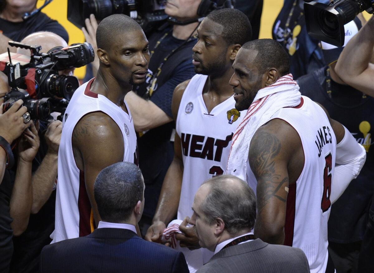 Miami's Big Three of Chris Bosh, left, Dwyane Wade and LeBron James exhale after the Heat's overtime victory over San Antonio in Game 6 of the NBA Finals.