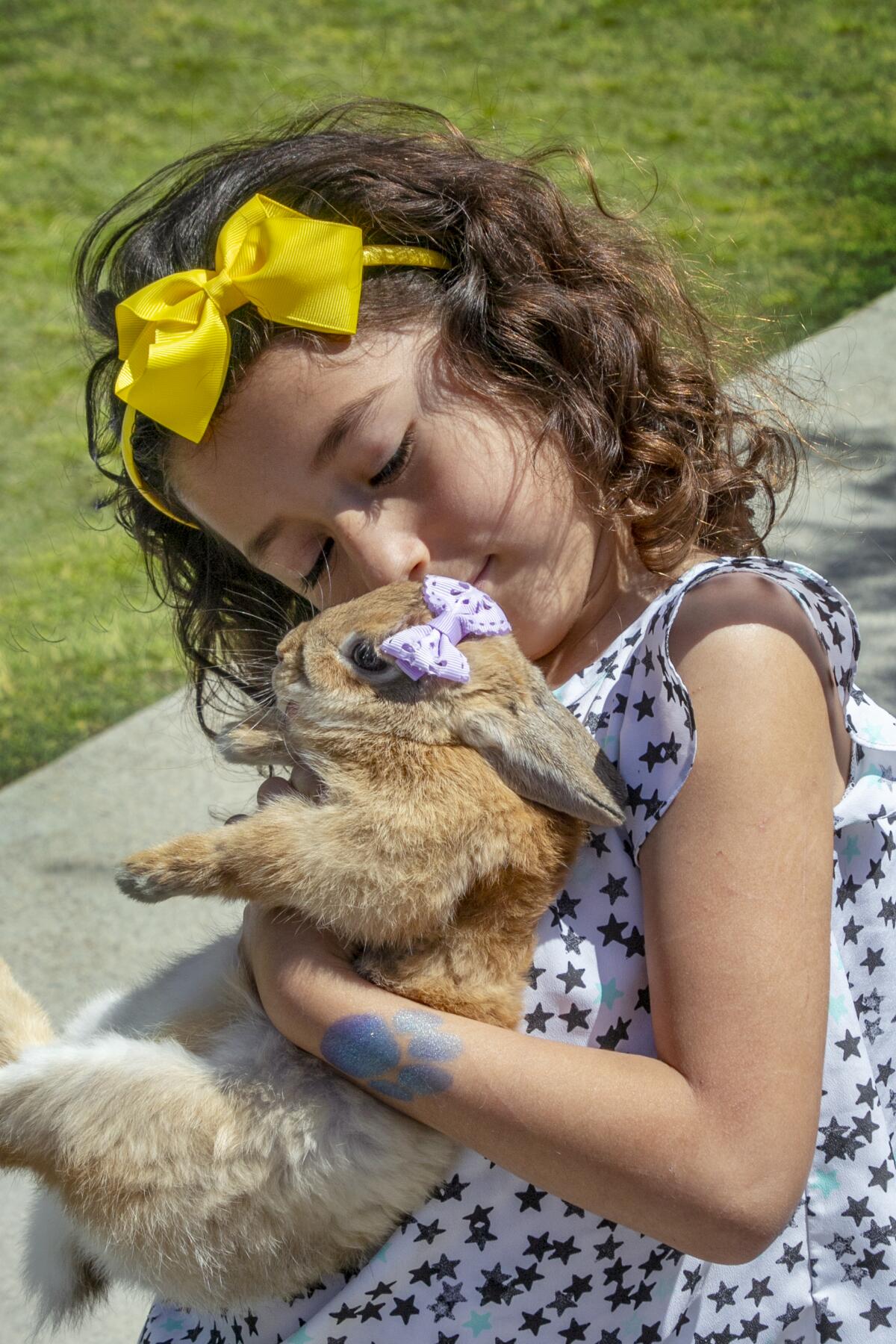 Candy Arredondo cuddles her bunny wearing an Easter bow.