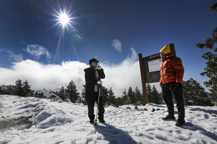WRIGHTWOOD, CA - MARCH 24, 2020 - Ignoring state-wide lockdown caused by coronavirus pandemic Hanna Shin, left, and Richard Hong on a crisp and chilly morning at Inspiration Point, that is 7381 feet high along Highway 2, above Wrightwood.(Irfan Khan / Los Angeles Times)