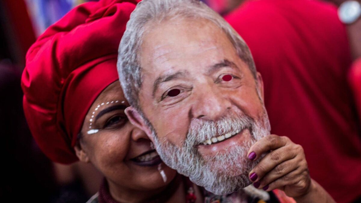 A Workers' Party supporter holds a mask in the likeness of former President Luiz Inacio Lula da Silva at a rally in Rio de Janeiro for the party's presidential candidate, Fernando Haddad.