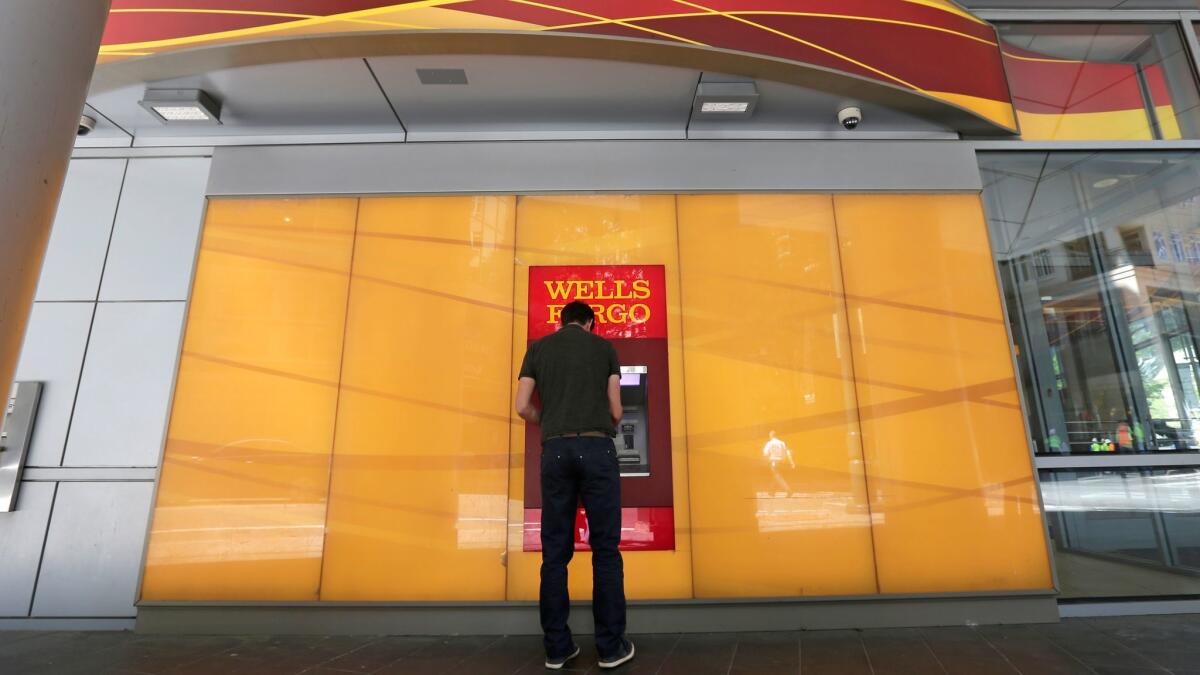 A man uses a Wells Fargo ATM.