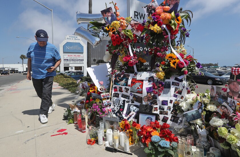 A man stops at a memorial shrine erected on West Coast Highway in Newport Beach on Wednesday.
