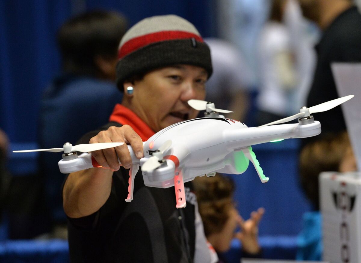 A consultant holds a drone by firm HiTec during the first-ever Drone Expo in Los Angeles last December. Since then, consumer drone sales have soared - and are still climbing.