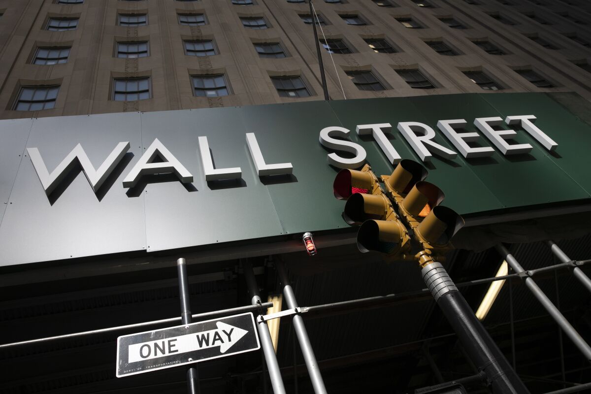 FILE -In this June 16, 2020 file photo, a sign for a Wall Street building is shown in New York. Stocks are opening mostly lower on Wall Street Thursday, Aug. 13, a day after the S&P 500 closed just below its pre-pandemic record high. (AP Photo/Mark Lennihan, File)