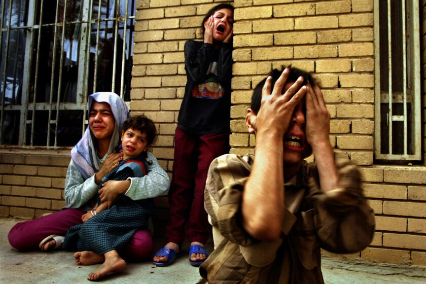 BAGHDAD, IRAQ-April 11, 2003-An Iraqi family grieves in horror at the homecoming of three dead family members shot by U.S. Marines on April 9, 2003. in Baghdad when the men failed to stop their car upon English command. (Carolyn Cole / Los Angeles Times)