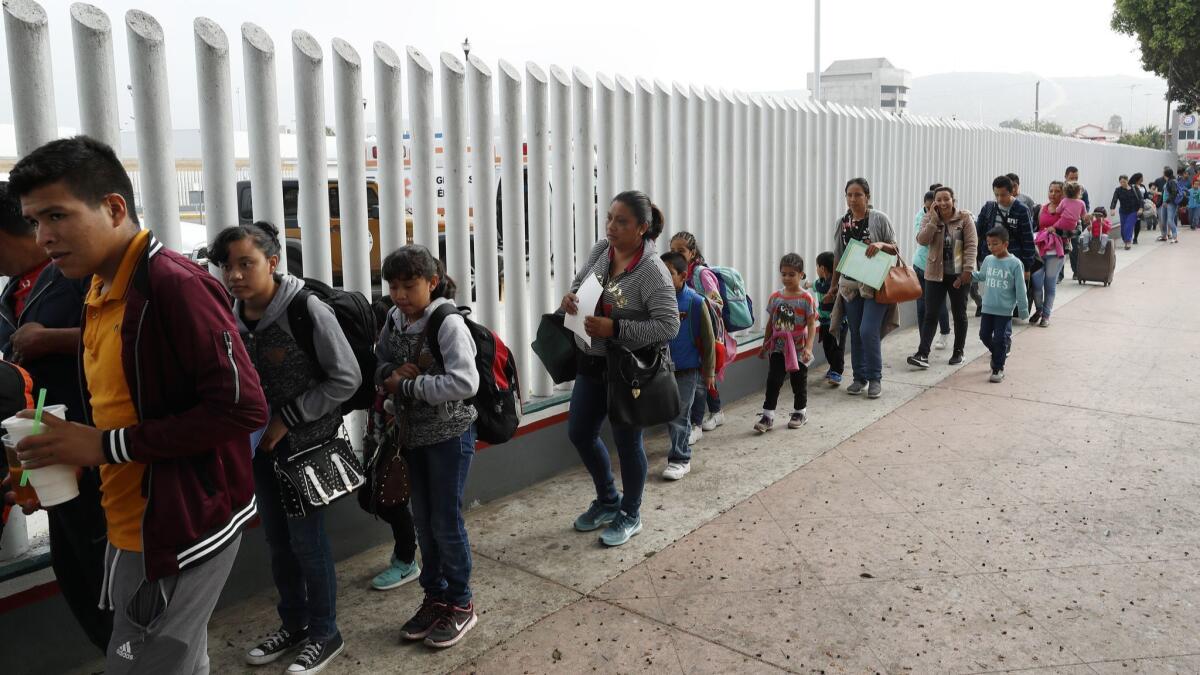 Migrants from Central America line up at the U.S. border crossing in Tijuana to begin the process of seeking asylum on July 26.