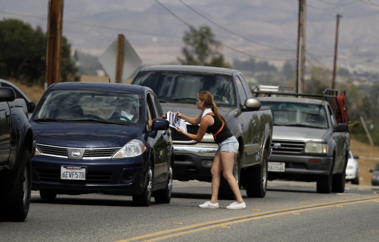 Ashley Cathers hands out fliers on Scott Road in Menifee as the search continues for Terry Dewayne Smith.