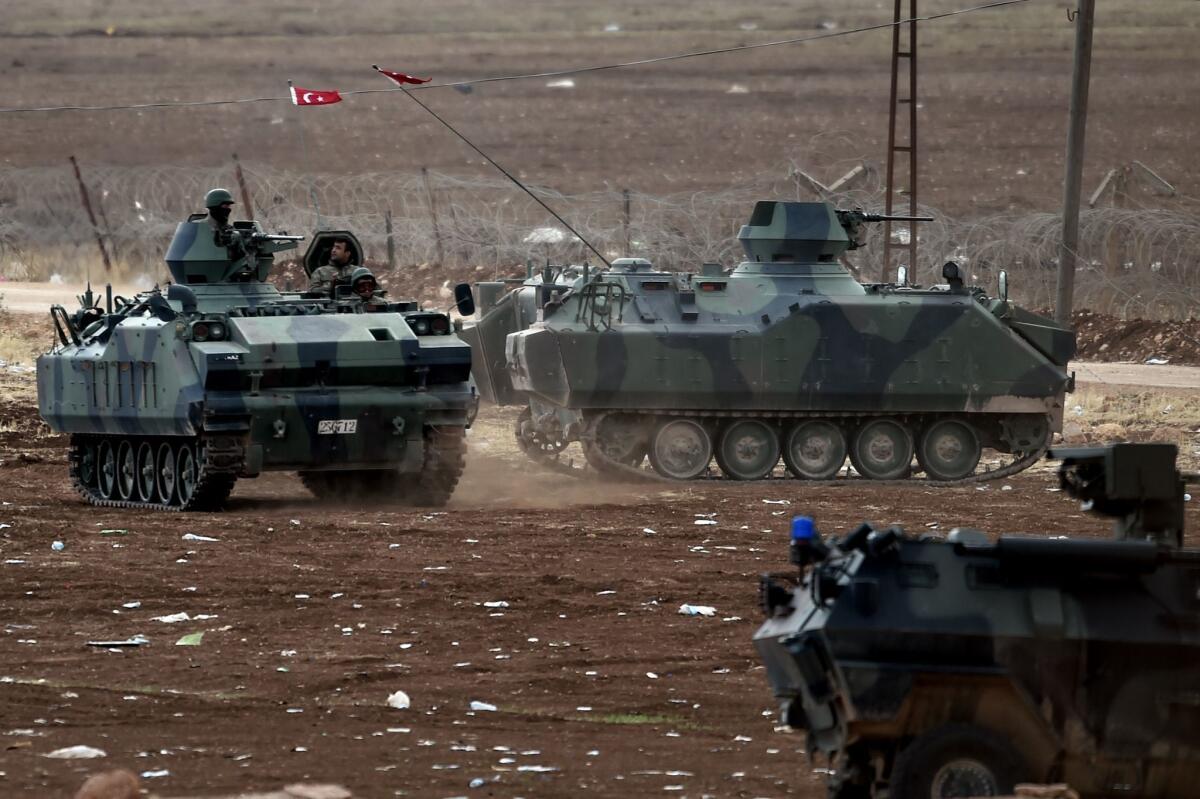 Turkish armored vehicles patrol the border on Oct. 12 near the Syrian town of Kobani, also known as Ayn al-Arab.
