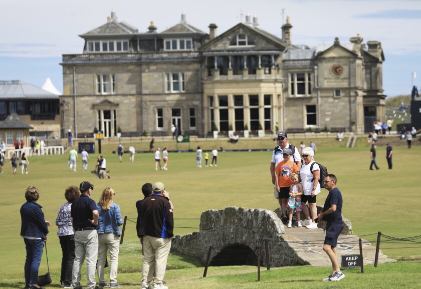 Golf enthusiasts take pictures on the Swilkan Bridge on the 18th hole in St. Andrews.