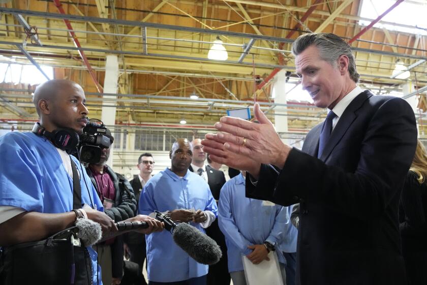 Incarcerated men visit with California Gov. Gavin Newsom after he spoke inside an empty warehouse at San Quentin State Prison in San Quentin, Calif., Friday, March 17, 2023. Gov. Newsom plans to transform San Quentin State Prison, a facility in the San Francisco Bay Area known for maintaining the highest number of prisoners on death row in the country. Newsom said Friday his goal is to turn the prison into a place where inmates can be rehabilitated and receive job training before returning to society. (AP Photo/Eric Risberg)