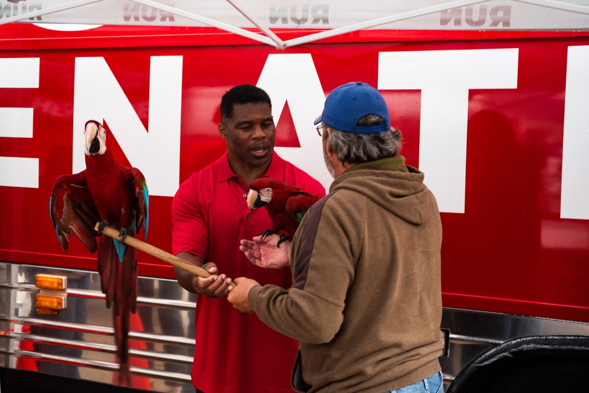 Herschel Walker takes photos with a supporter.