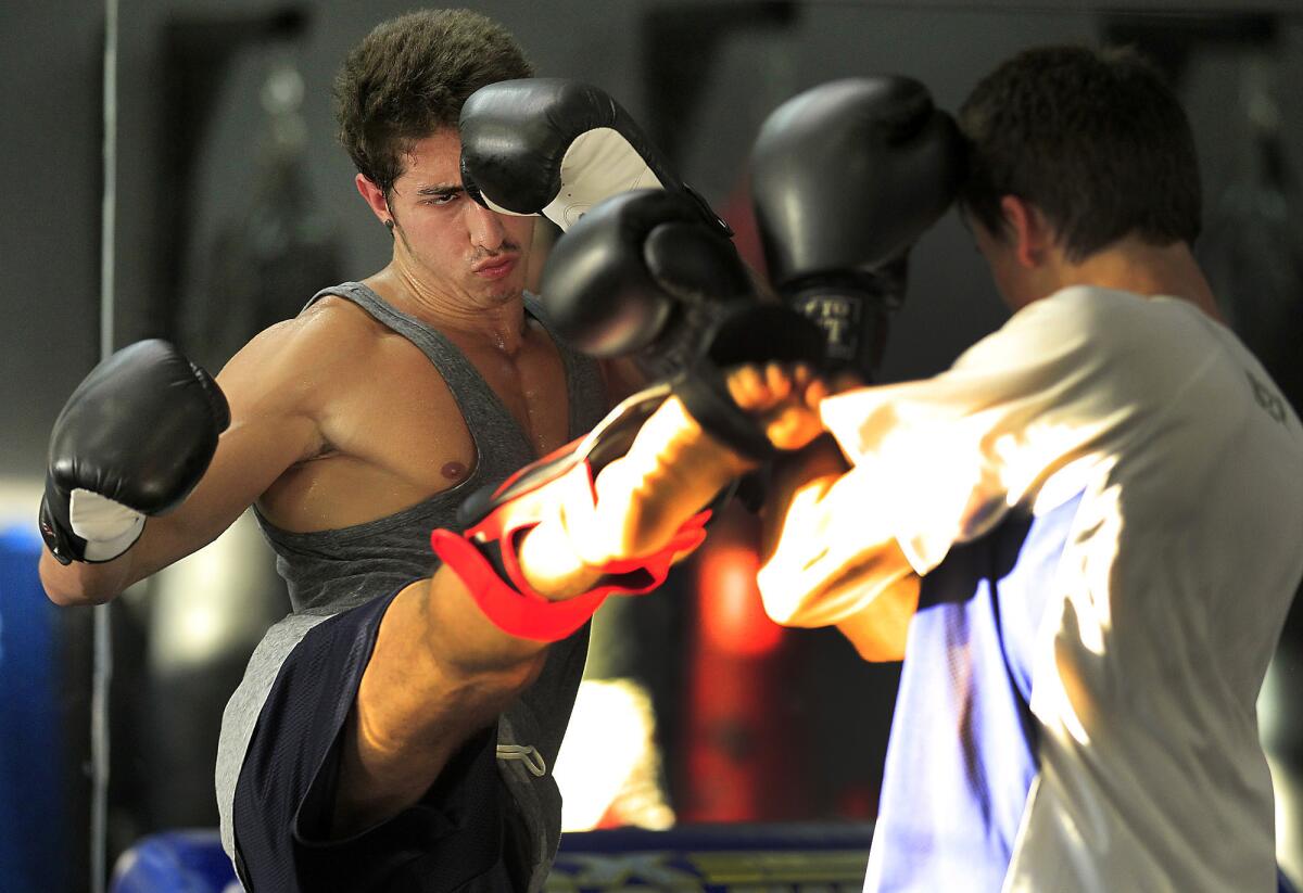 Samer Hamwi, 20, left, places a kick near the head of sparring partner Nick Matute, 18, right, at the Shark Tank MMA Gym.