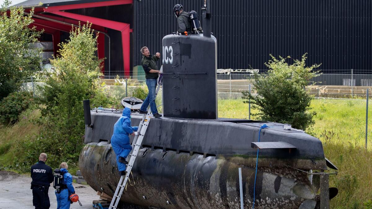 Police technicians board Peter Madsen's submarine after it was recovered on a pier in Copenhagen harbor on Aug. 13, 2017.