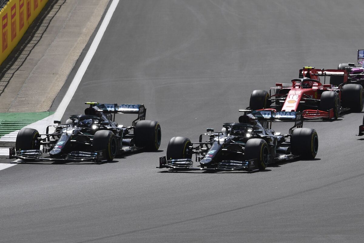 Mercedes driver Valtteri Bottas of Finland, left and Mercedes driver Lewis Hamilton of Britain steer their cars during the British Formula One Grand Prix at the Silverstone racetrack, Silverstone, England, Sunday, Aug. 2, 2020. (Ben Stansall/Pool via AP)