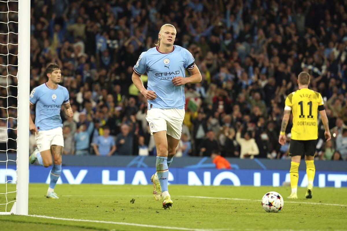 Manchester City's Erling Haaland, center, celebrates after scoring his side's 2nd goal during the group G Champions League soccer match between Manchester City and Borussia Dortmund at the Etihad stadium in Manchester, England, Wednesday, Sept. 14, 2022. (AP Photo/Dave Thompson)