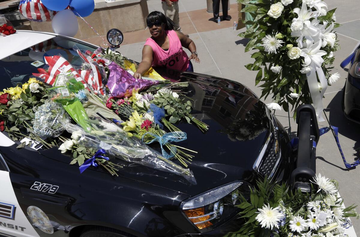 Cynthia Ware deposita flores en un monumento improvisado en las oficinas generales de la policía de Dallas el viernes 8 de julio de 2016, en Dallas, tras la muerte de cinco agentes por un francotirador. (AP Foto/Eric Gay)