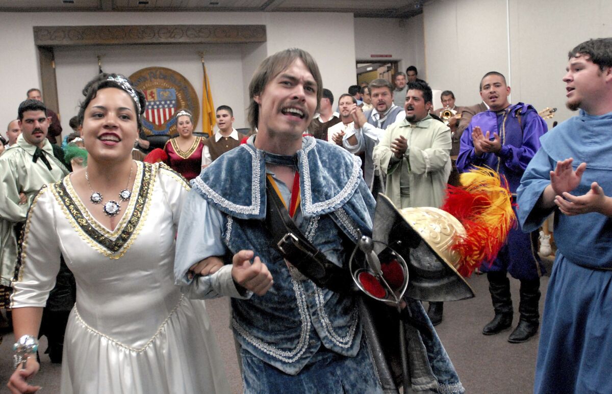 FILE - In this Sept. 5, 2006, file photo, Jessica Lucero, left, dressed as the Fiesta Queen, and Jaime Dean, right, dressed as 17th Century Spanish conquistador Don Diego de Vargas, dance and sing at Santa Fe City Hall in Santa Fe, N.M. New Mexico has retained its title as the nation's most heavily Latino state, with 47.7% of respondents to the 2020 census identifying ancestry linked to Latin America and other Spanish-speaking areas. The Census Bureau on Thursday, Aug. 12, 2021 released new demographic details culled from the census. (AP Photo/Jeff Geissler, File)