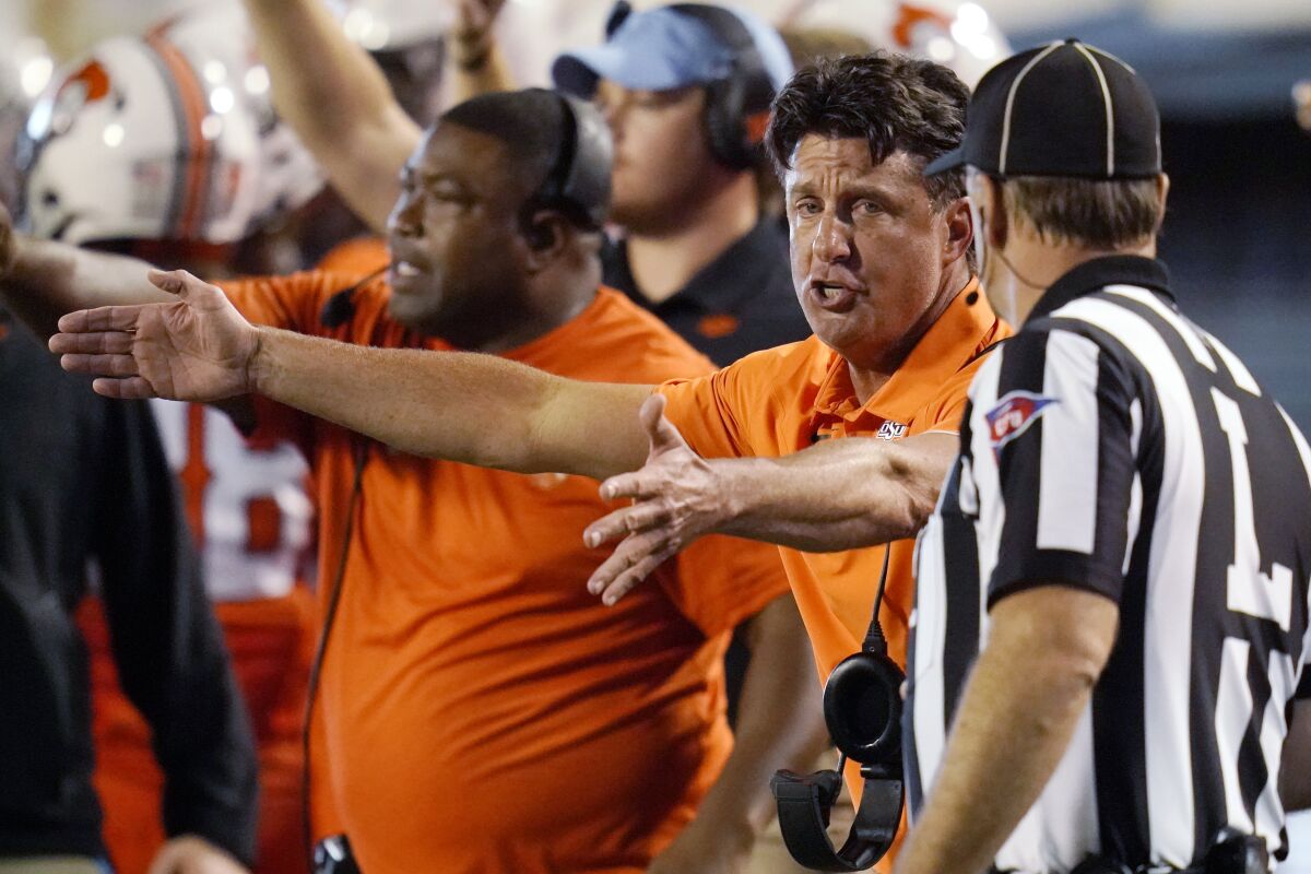Oklahoma State coach Mike Gundy talks with an official during the second half of the team's NCAA college football game against Missouri State, Saturday, Sept. 4, 2021, in Stillwater, Okla. (AP Photo/Sue Ogrocki)