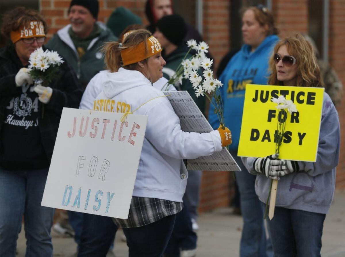 Supporters of Daisy Coleman pass out flowers before a rally outside the Nodaway County Courthouse in Maryville, Mo.