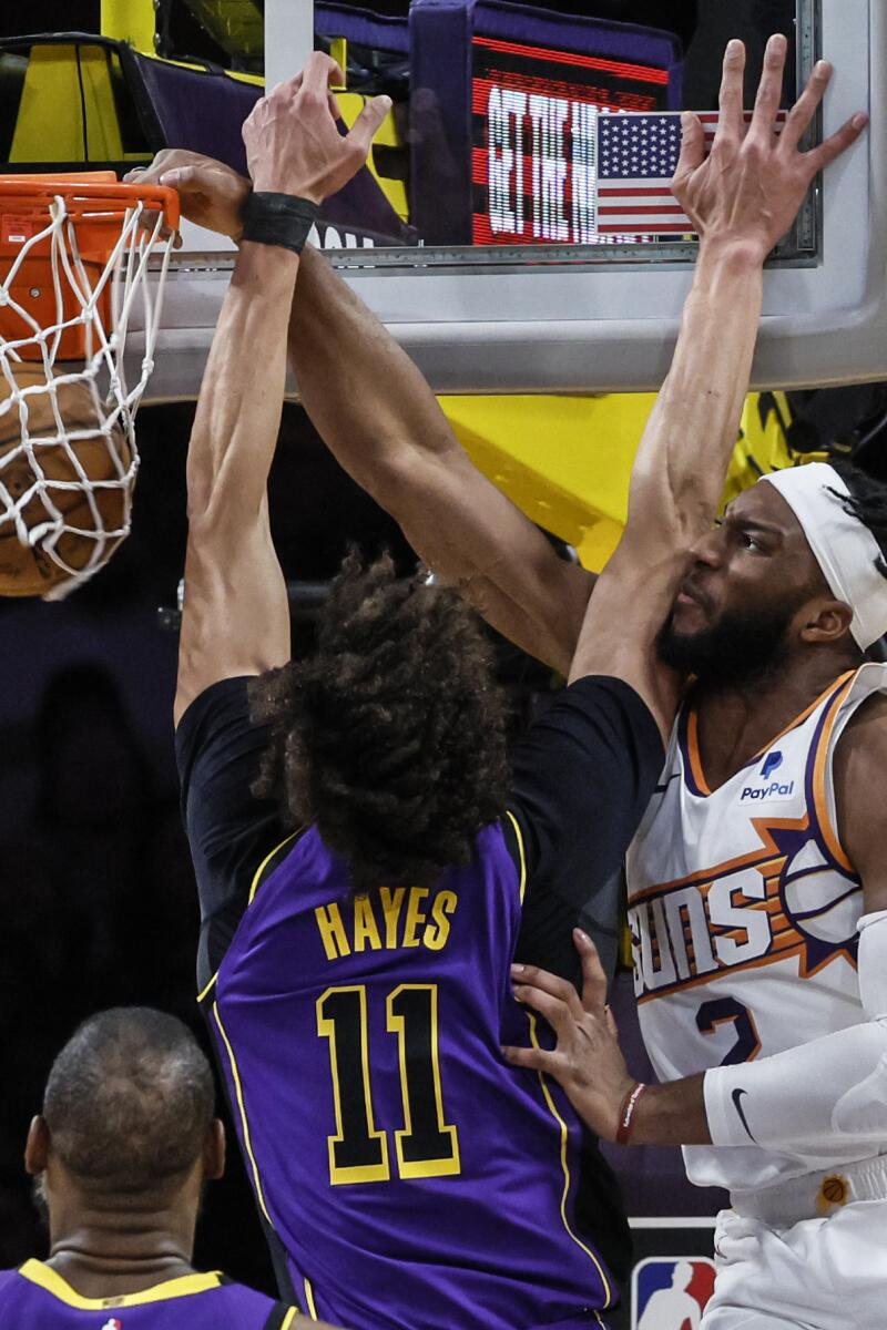 Phoenix Suns forward Josh Okogie dunks over Lakers center Jaxson Hayes in the first half.