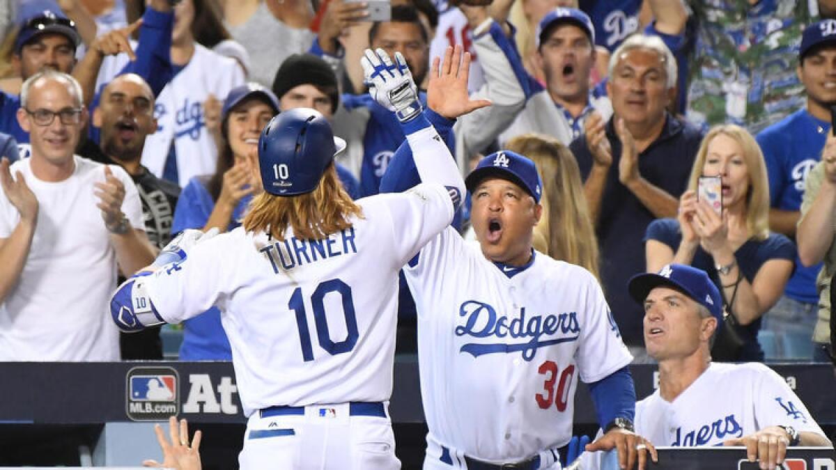 Dodgers third baseman Justin Turner celebrates his three-run, first-inning home run with manager Dave Roberts at Dodger Stadium on Friday.