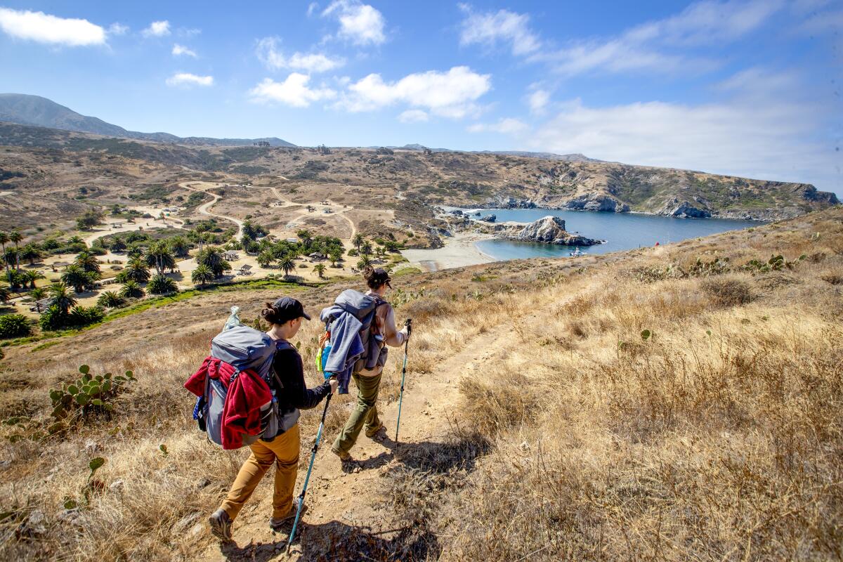 LITTLE HARBOR, CA - AUGUST 11: Hikers Erin Sakamoto, left, 21, and her sister Jenna Sakamoto, 19, both of Simi Valley, arrive at the Little Harbor campground after hiking the Trans-Catalina Trail from Two Harbors, the premier hike on Catalina Island spanning the total route for a total of 38.5 miles in Catalina Island on Tuesday, Aug. 11, 2020 in Little Harbor, CA. (Allen J. Schaben / Los Angeles Times)