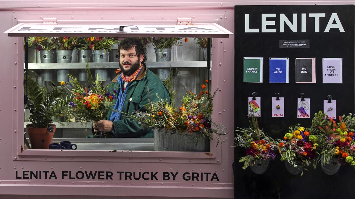 Nemuel DePaula, in beard and red bandanna, is seen holding a bouquet in the window of his flower truck.