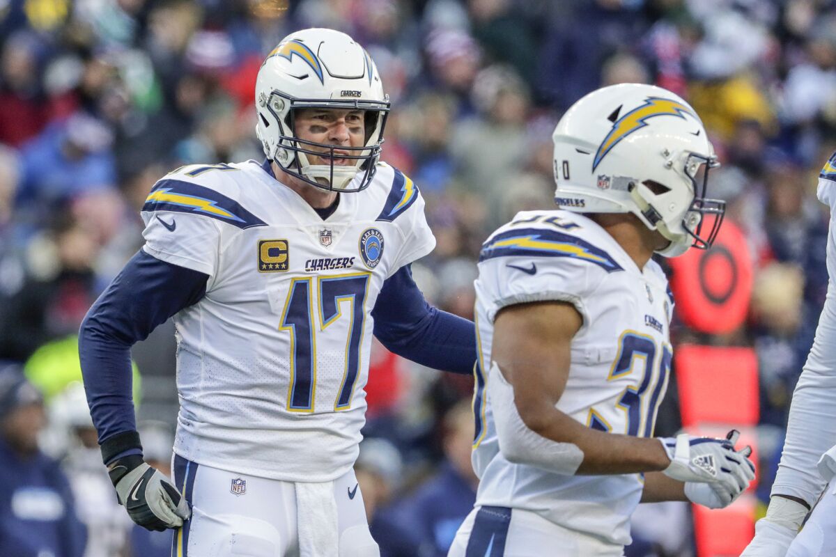 A frustrated Philip Rivers talks with running back Austin Ekeler after a broken play resulted in a sack late in the second quarter in the NFL AFC Divisional Playoff at Gillette Stadium on Sunday.
