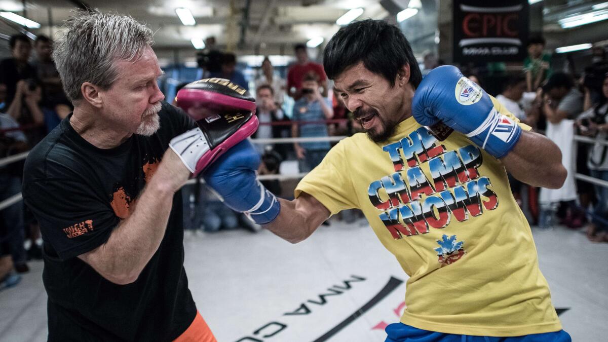 Manny Pacquiao, right, takes part in a sparring session with trainer Freddie Roach during a media session in Hong Kong on Oct. 27.