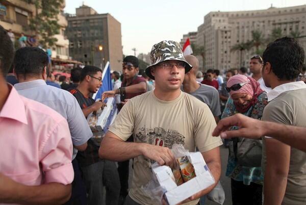 Ahmed Maher hands out juice boxes to demonstrators in Cairo's Tahrir Square. The leader of the April 6 Youth Movement helped launch last winter's revolution.