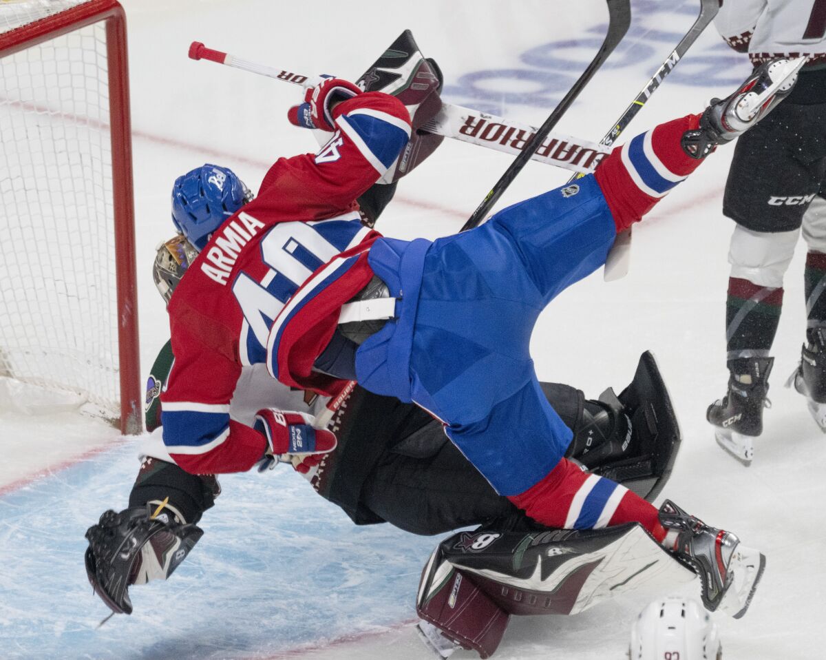 Montreal Canadiens right wing Joel Armia (40) skates into Arizona Coyotes goaltender Karel Vejmelka (70) during the first period of an NHL hockey game, Tuesday, March 15, 2022 in Montreal. (Ryan Remiorz/The Canadian Press via AP)