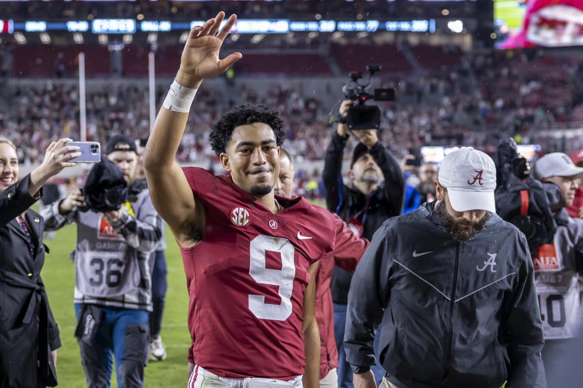Alabama quarterback Bryce Young salutes the fans as he leaves the field Nov. 26, 2022.