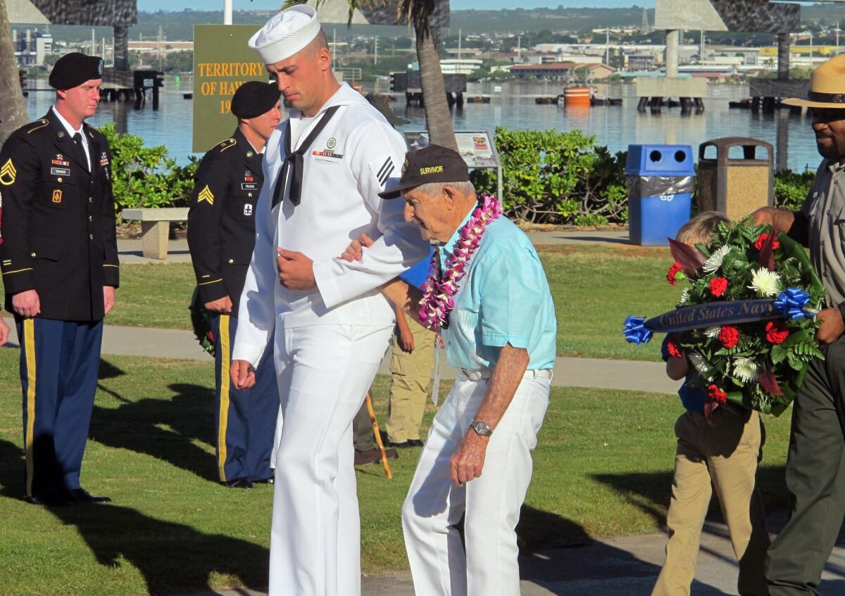 A sailor escorts Navy veteran and Pearl Harbor survivor John Chapman during a ceremony marking the 73rd anniversary of the Japanese attack that drew the U.S. into World War II.