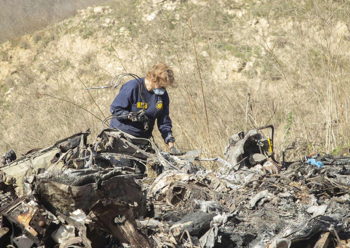 NTSB investigator Carol Hogan examines wreckage as part of the NTSB’s investigation of the helicopter crash near Calabasas.
