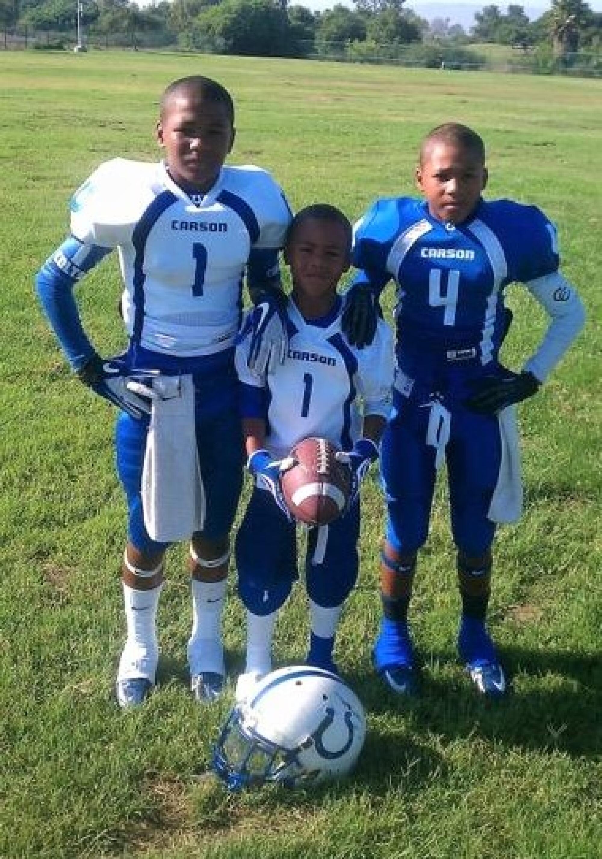 Williams brothers Max, left, Marcelles, center, and Macen pose for a photo during their youth in football gear.