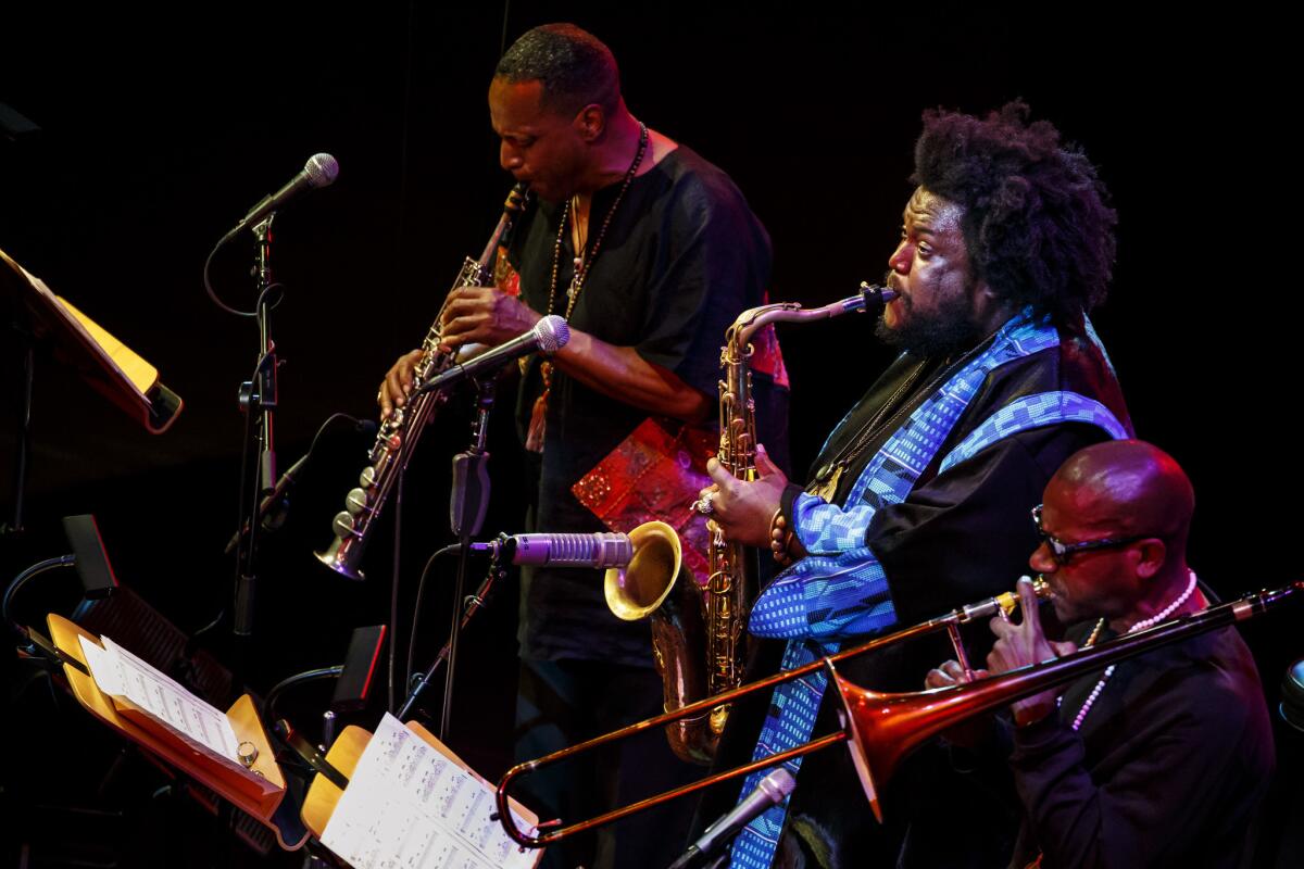 Saxophonist Kamasi Washington, center, performs at Disney Hall with father Rickey, left, and Ryan Porter.