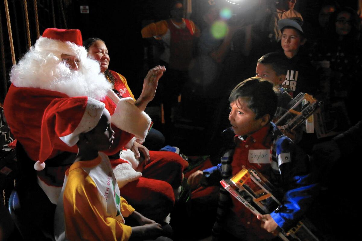 "Santa" Al McLaughlin waves to children as they receive their toys at the 50th annual F. Ruth Moore Christmas party.