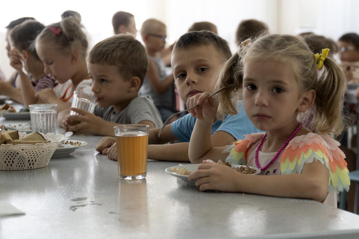 Niños de orfanatos de la región de Donetsk fotografiados durante el almuerzo en un campamento d