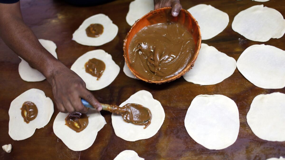 Genaro Solis fills coyotas with jamoncillo, made with milk and sugar, at Coyotas Doña Maria in Hermosillo, Mexico. Solis makes about 1,500 of the traditional Sonoran pastries daily.