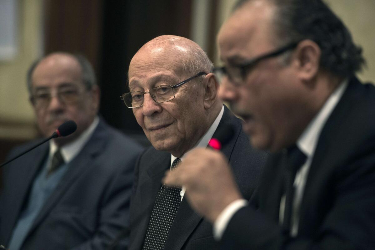 Mohamed Fayek, center, head of Egypt's National Council for Human Rights, and deputy Abdelghafar Shokr, left, listen to panel member Nasser Amin at a news conference in Cairo.