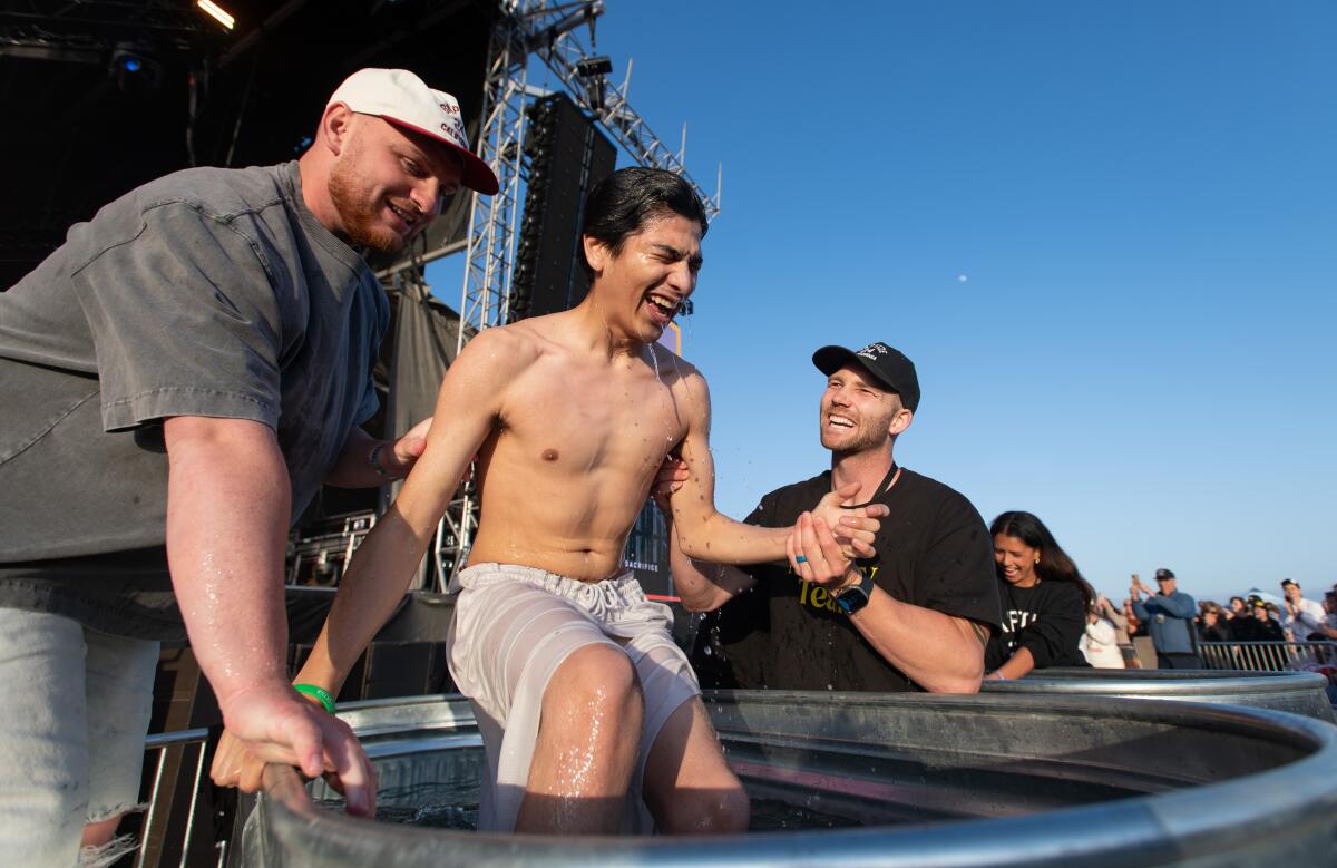 Albert Garcia, 19, of Boron, gets baptized in front of thousands at Huntington State Beach Sunday, May 19.