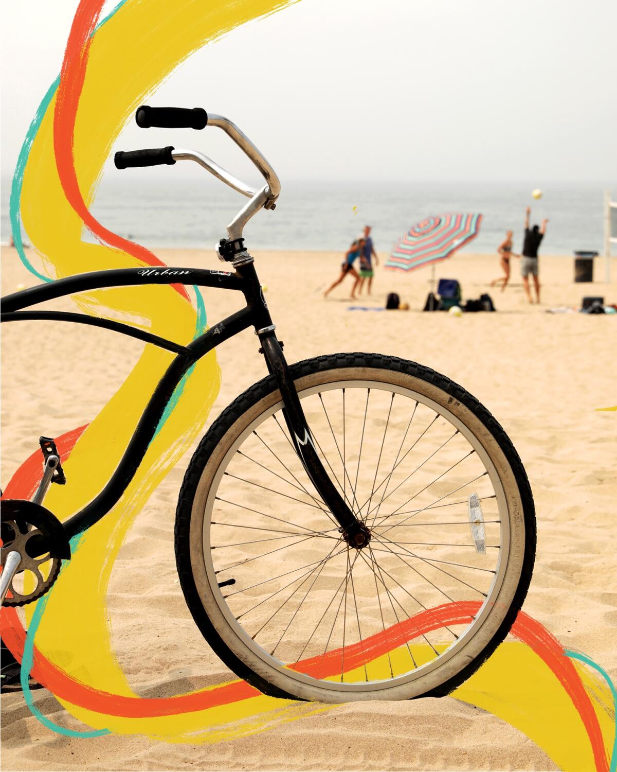 A bicycle on the beach with people playing beach volleyball in the background.