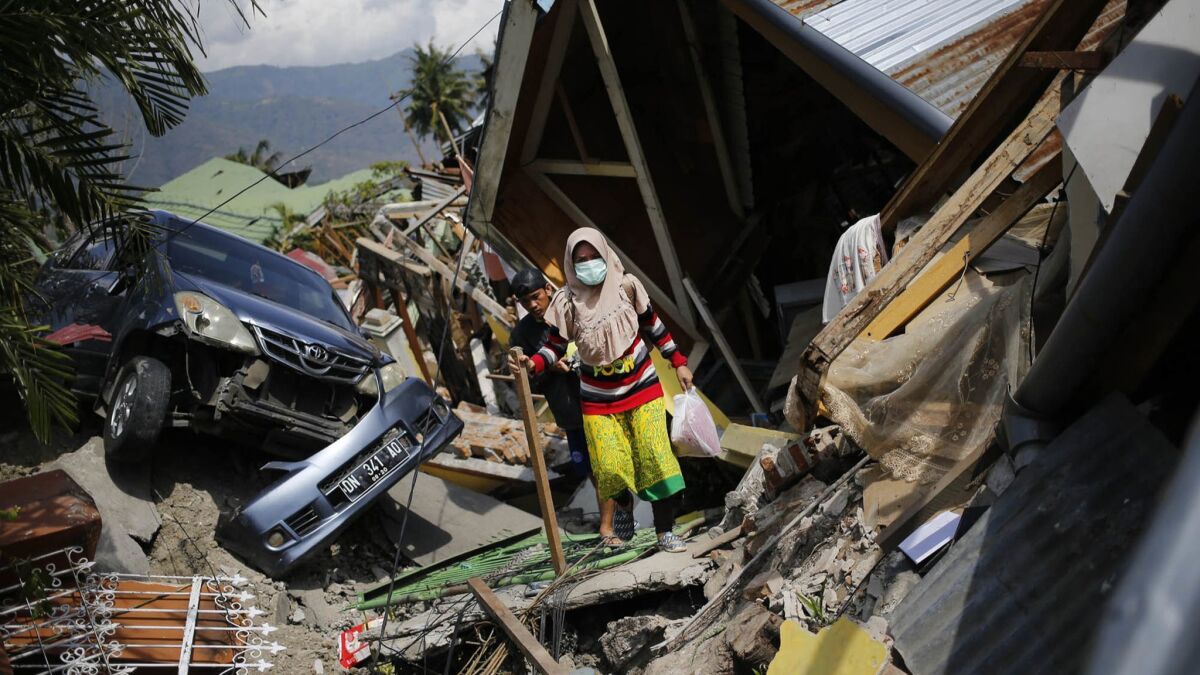 A woman makes her way through the rubble of homes in the Balaroa neighborhood of Palu in Central Sulawesi, Indonesia, on Oct. 2, 2018.