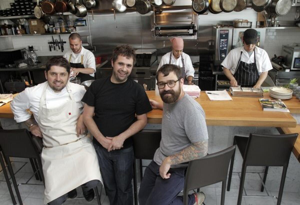 From left, Ludo Lefebvre (chef-co-owner), Vinny Dotolo (co-owner) and Jon Shook (co-owner) of the new Trois Mec restaurant with the kitchen staff behind them in the restaurant.