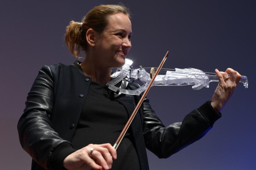 French politician Axelle Lemaire plays a 3-D-printed violin in November. The buzz, or lack thereof, around 3-D printing will be something to watch at CES.