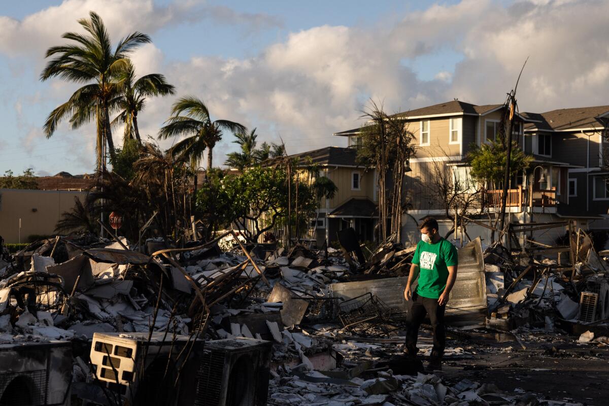 A Mercy Worldwide volunteer makes a damage assessment of a charred apartment complex destroyed by wildfire in Lahaina.