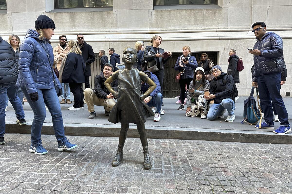 Visitors crowd around a sculpture. 